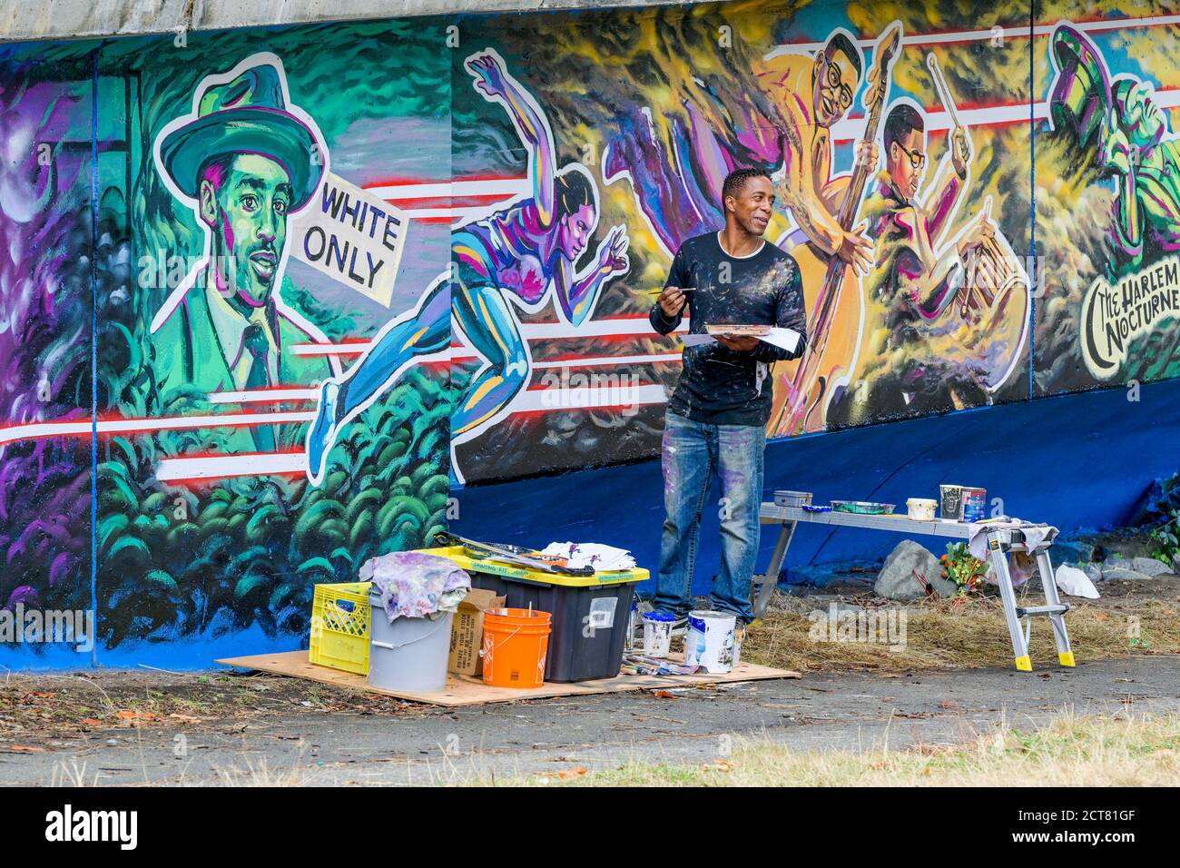 Artista Anthony Joseph dipingere Hogan's Alley, Black History murale su Dunsmuir Viaduct, Vancouver, British Columbia, Canada Foto Stock