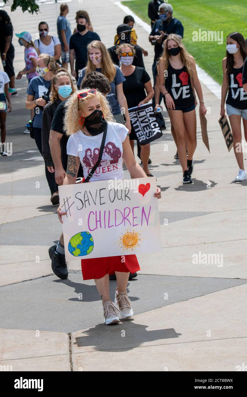 St. Paul, Minnesota. 22 agosto 2020. I giovani marciano e radunano per porre fine alla violenza. Una donna protester che tiene un segno di salvataggio dei nostri bambini. Foto Stock