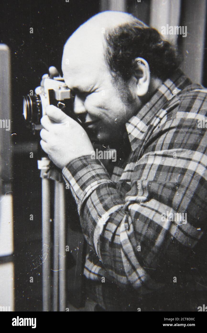 Bella fotografia in bianco e nero degli anni '70 di un normale fotografo di un ragazzo utilizzando la sua macchina fotografica. Foto Stock