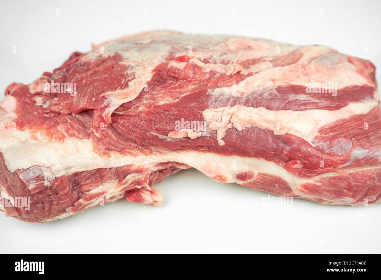 grosso pezzo di filetto di maiale grasso, carne cruda, isolato su bianco Foto Stock