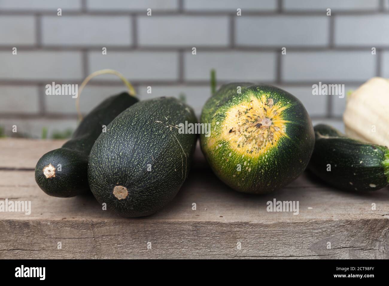 Zucca e zucchine verdi sono su pavimento in legno, primo piano foto Foto Stock