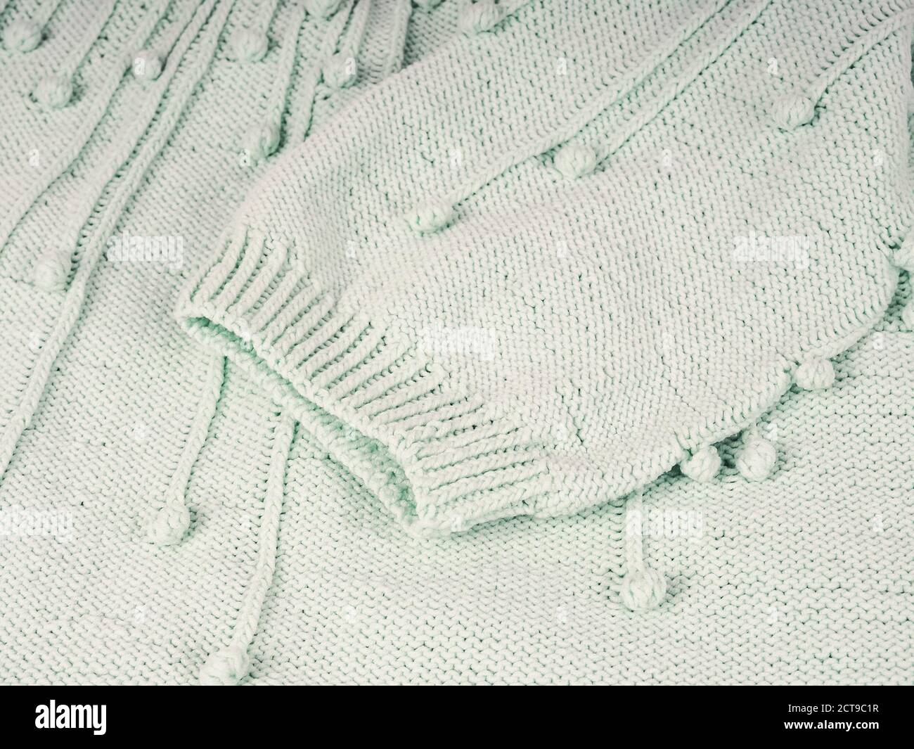Sfondo lavorato a maglia astratto. Pullover in lana con maniche. Primo piano dell'immagine del motivo lavorato a maglia. Foto Stock