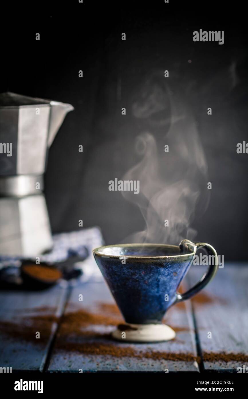 Cup su cafetiera sul tavolo con la polvere di caffè Foto Stock