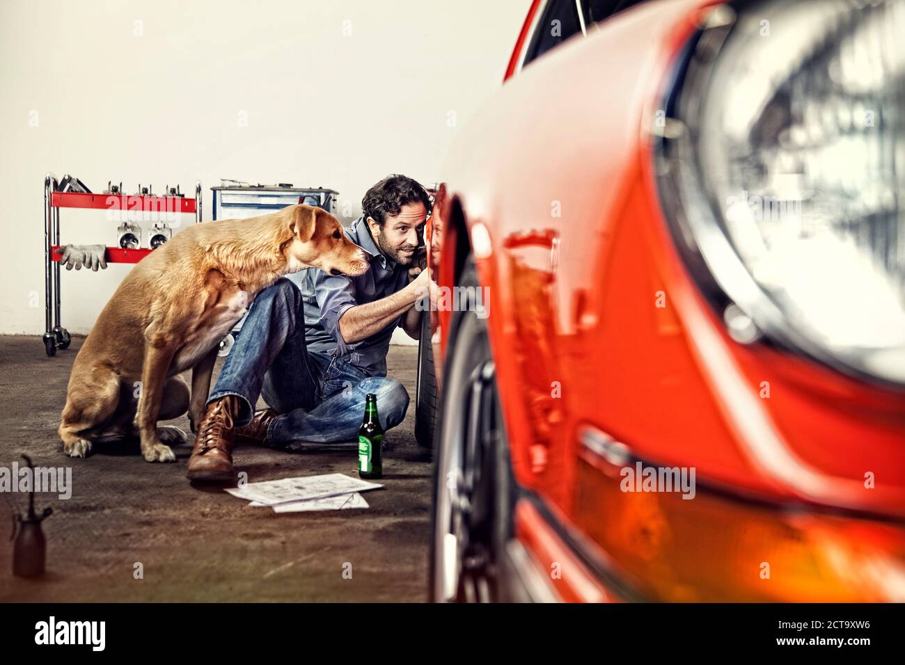 Uomo che ripara la sua auto d'epoca Foto Stock