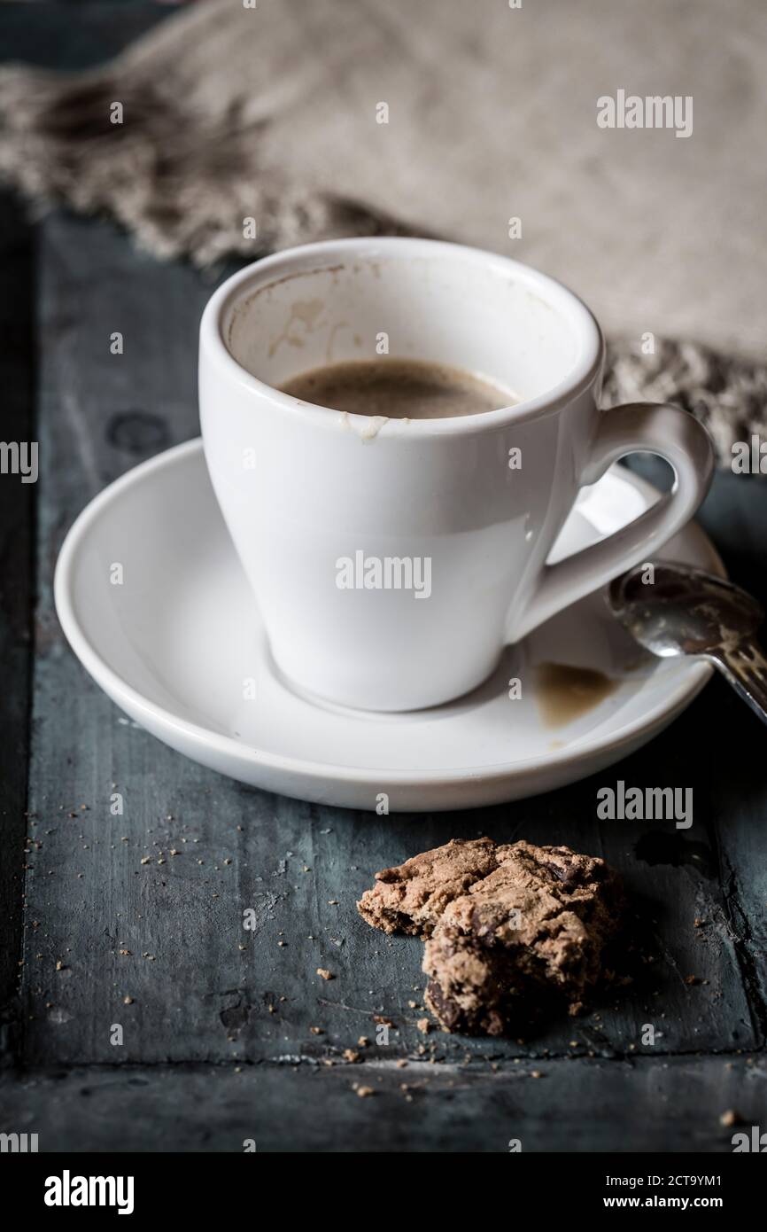 Tazza di caffè e avanzi di cioccolato cookie sul legno grigio Foto Stock
