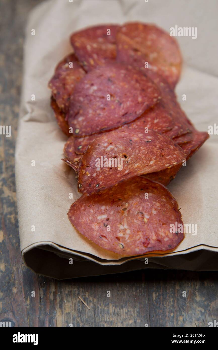 Salame di affettare sul tavolo di legno Foto Stock