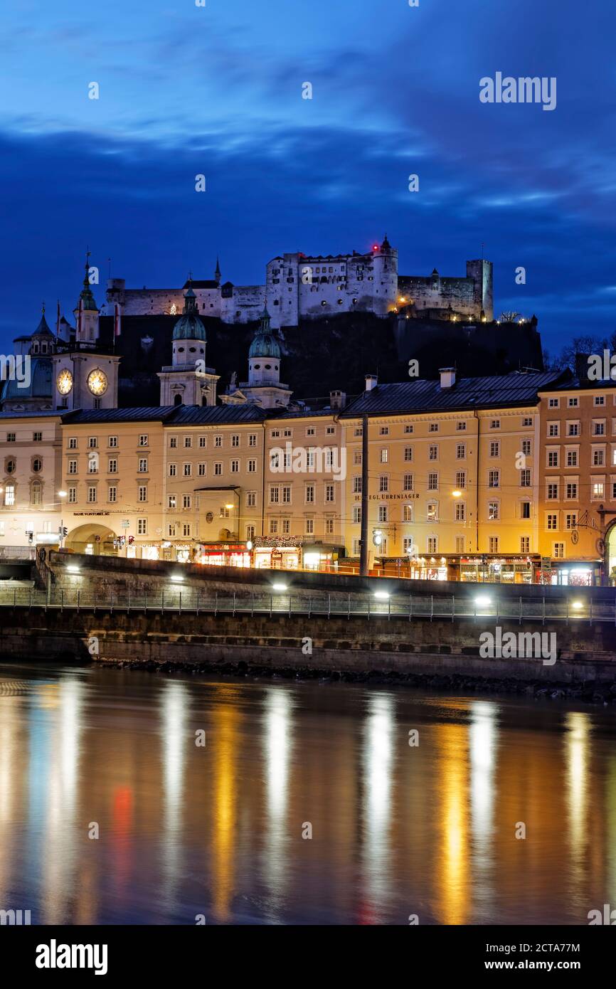 Austria, Stato di Salisburgo, Salisburgo, Castello di Hohensalzburg con la città vecchia e le torri della cattedrale di Salisburgo, il fiume Salzach in serata Foto Stock