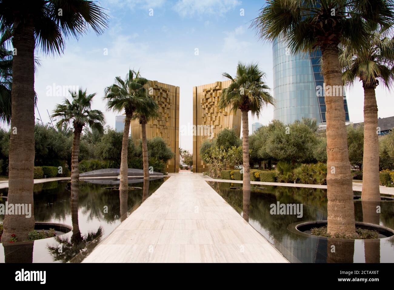 Il monumento d'oro per celebrare il giubileo della Costituzione Kuwait con palme e fontana di fronte. Al Shaheed Park, Kuwait. Foto Stock