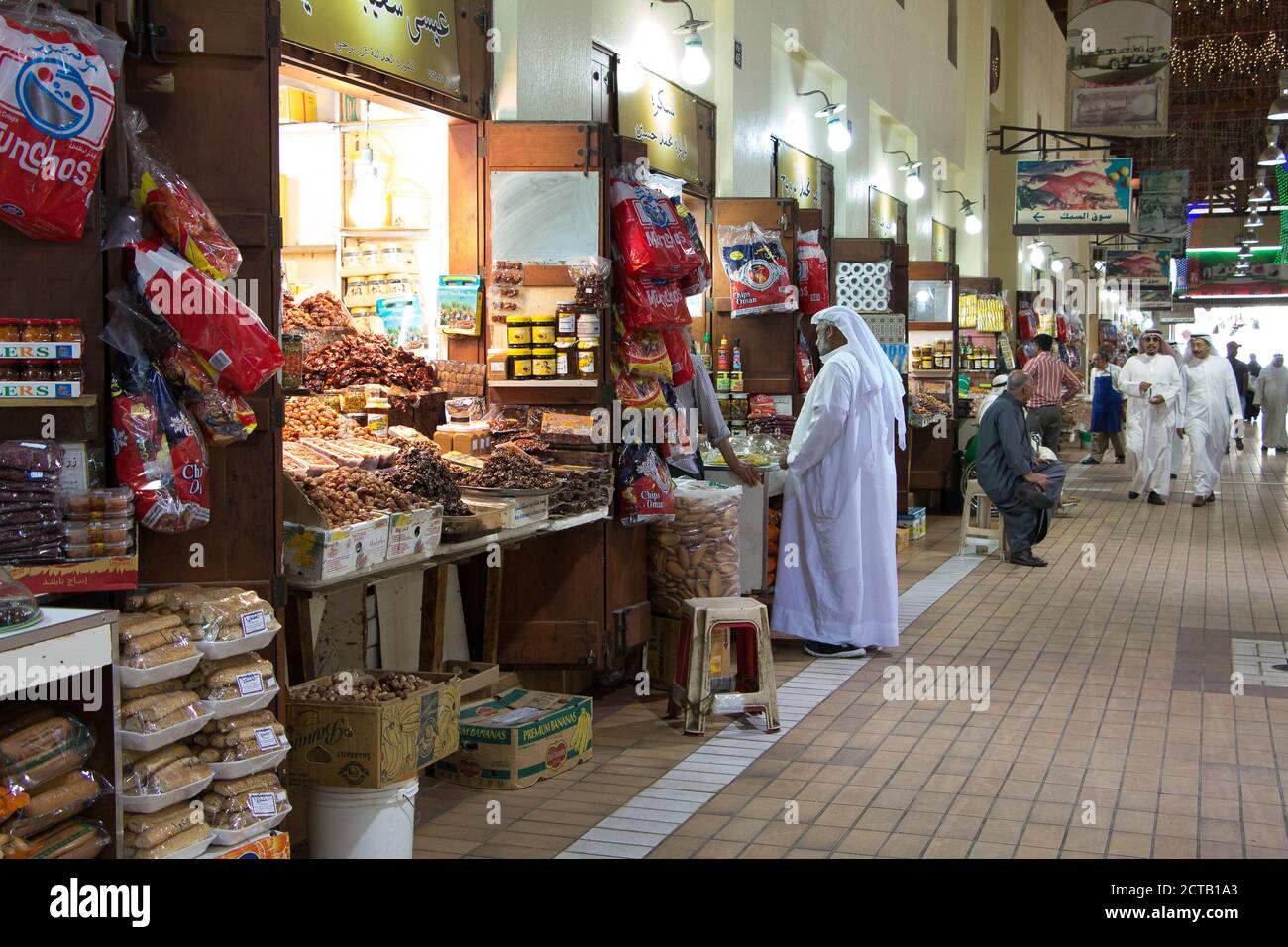 Un uomo in dishdashia shopping al mercato di Souq Mubarakiya, Kuwait. Foto Stock