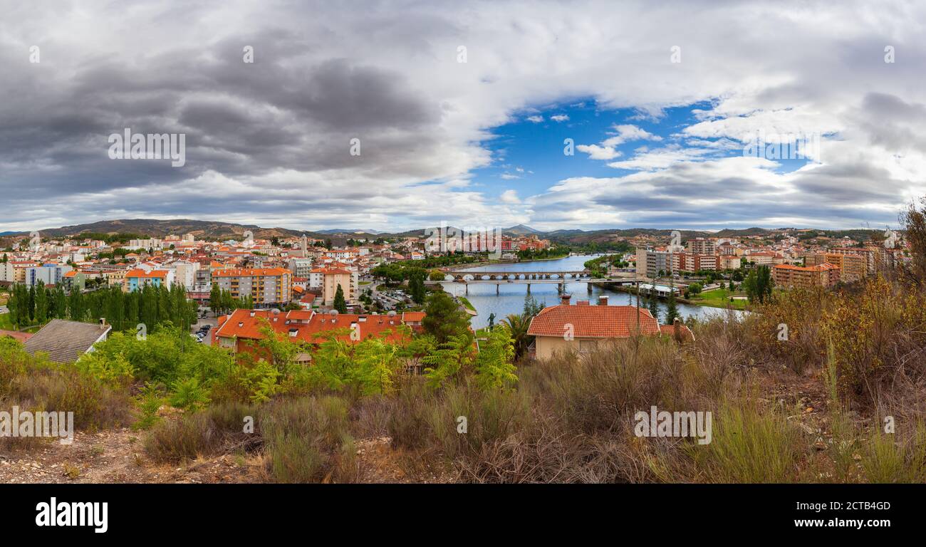 Paesaggio urbano della città di Mirandela nel nord del Portogallo. Vista panoramica sulle rive del fiume Tea con il tradizionale ponte romano e. Foto Stock