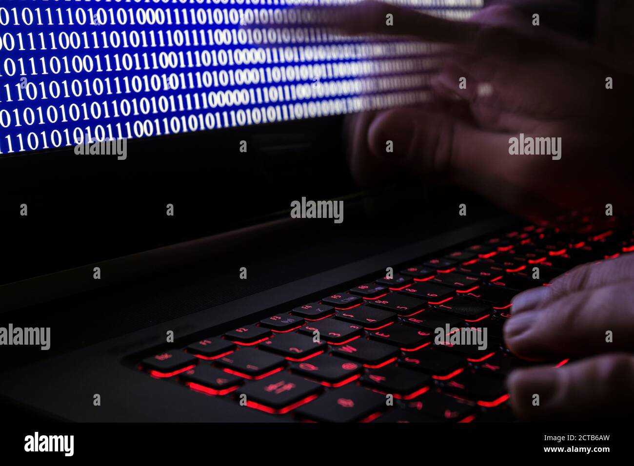 Il computer hacker programma un virus su un portatile Foto Stock