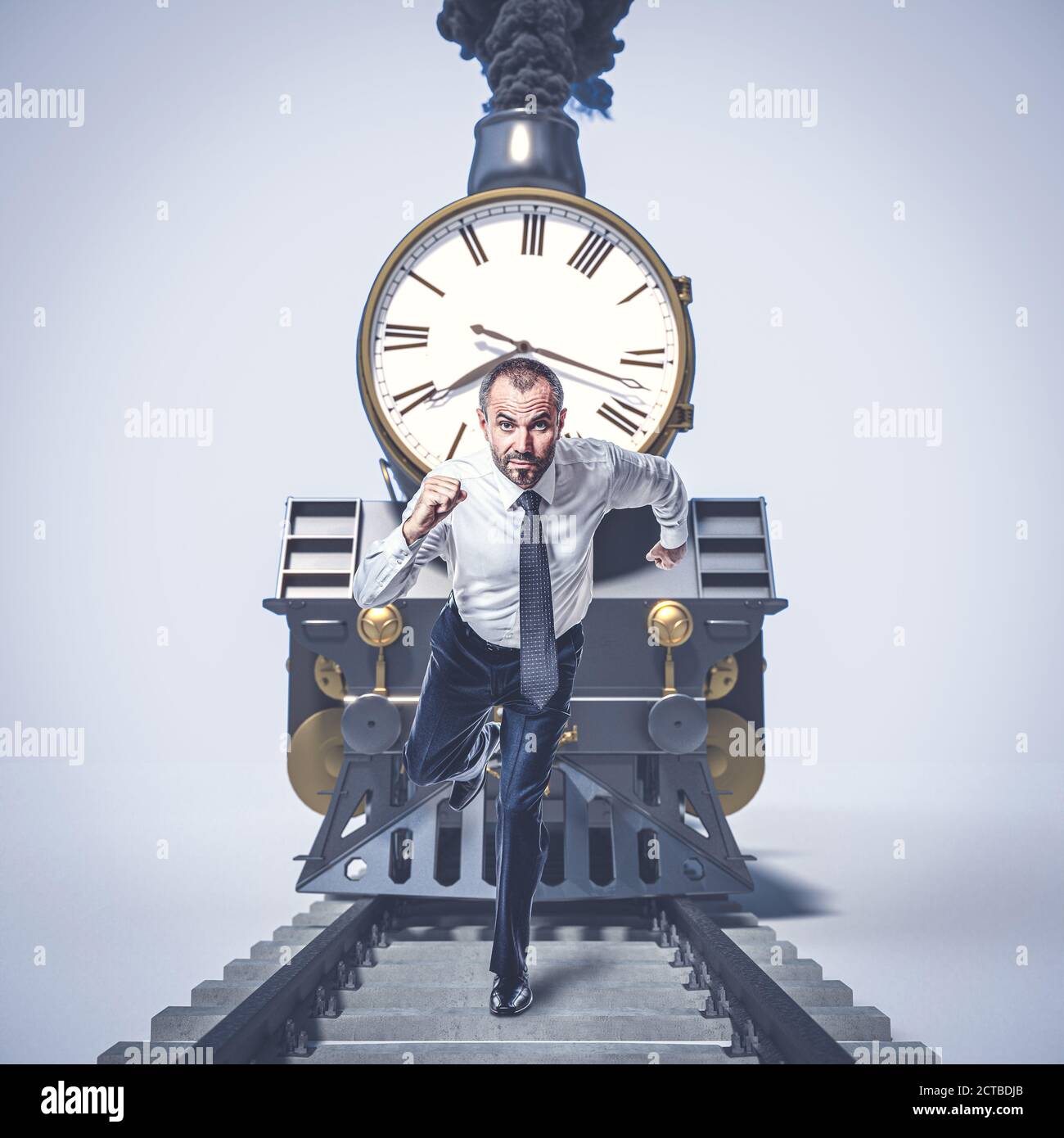 uomo che corre sulle piste e si allontana da un treno con un grande orologio. concetto di tempo, urgenza. Foto Stock