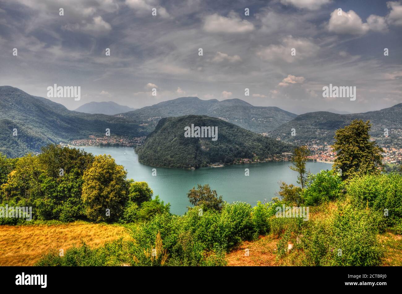 Lago Alpino Lugano con montagna e confine tra Svizzera e Italia. Foto Stock