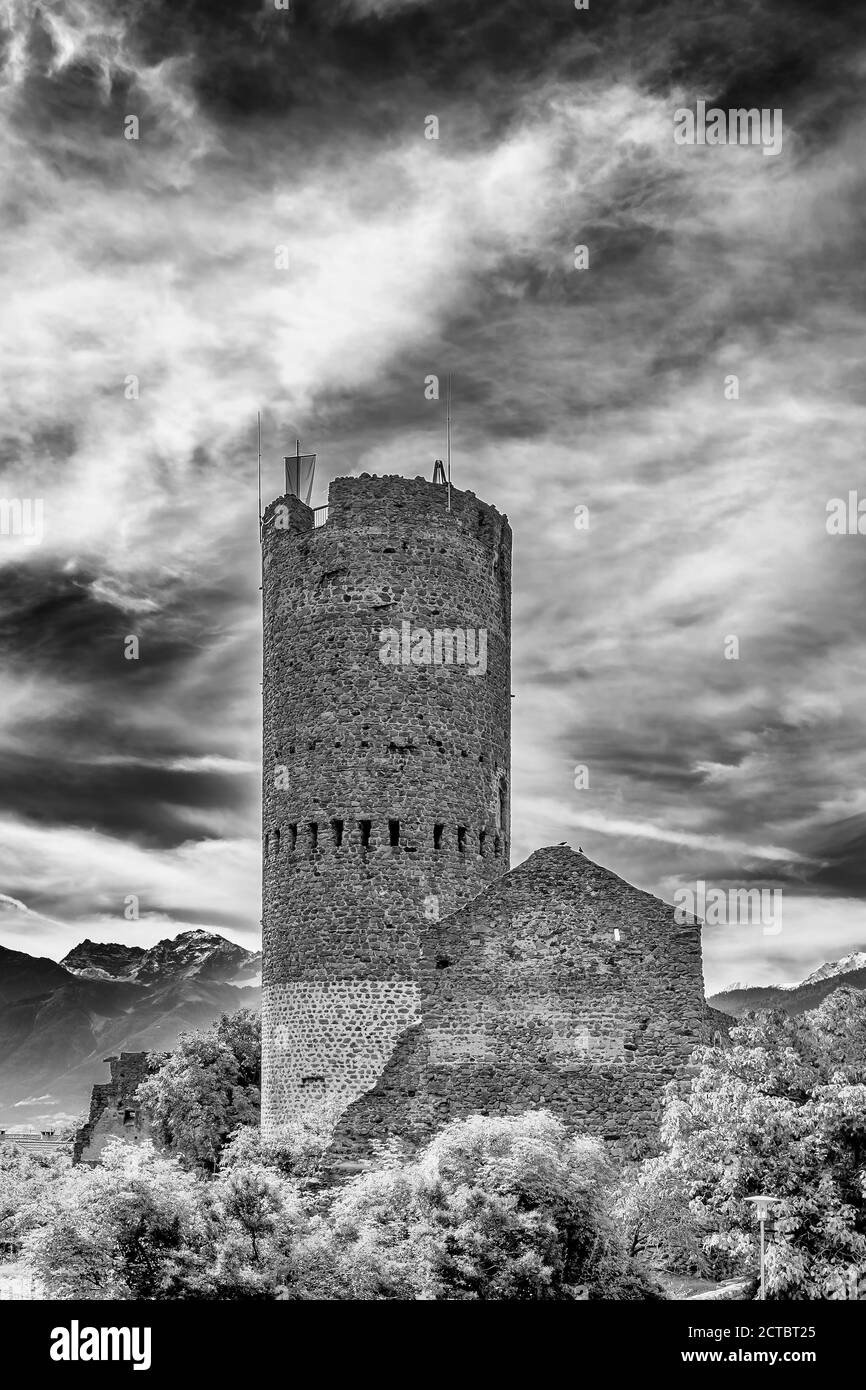 Vista in bianco e nero sull'antica Torre Frohlich nel centro storico di Malles Venosta, Alto Adige, Italia Foto Stock