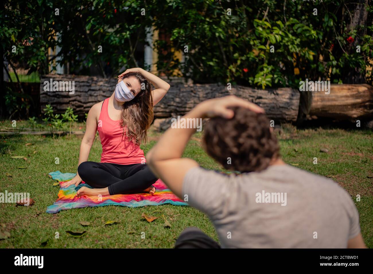 donna che indossa una maschera su una classe di fitness all'aperto Foto Stock