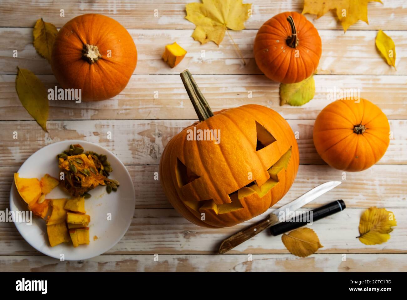 Scultura di Halloween. Primo piano di zucche o jack-o-lantern e coltello a casa. Decorazione e concetto di vacanza Foto Stock