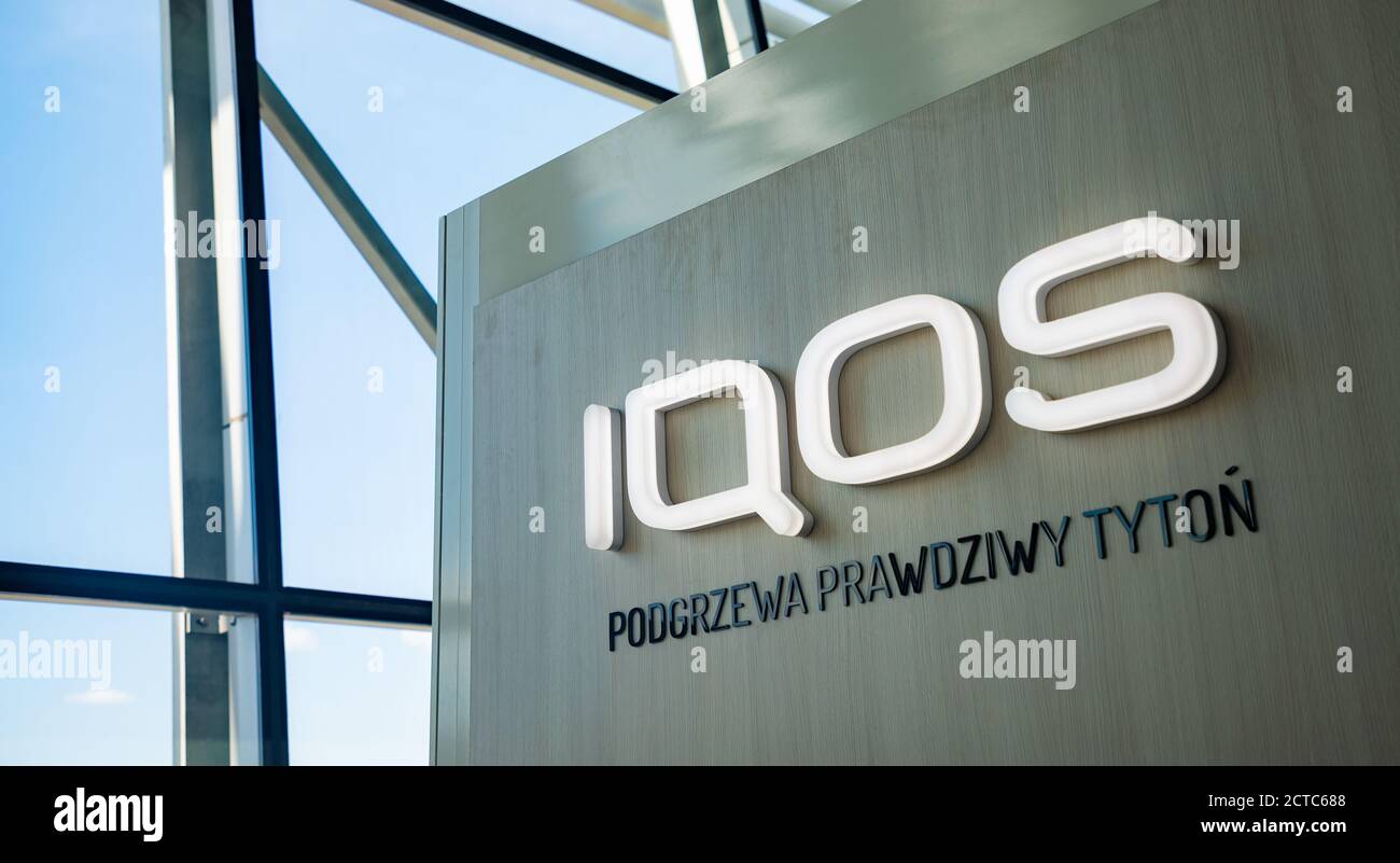 Immagine del logo IQOS sul lato di uno stand all'interno del terminal dell'aeroporto Chopin di Varsavia. Lo slogan recita 'Heats Real Tobacco'. Foto Stock