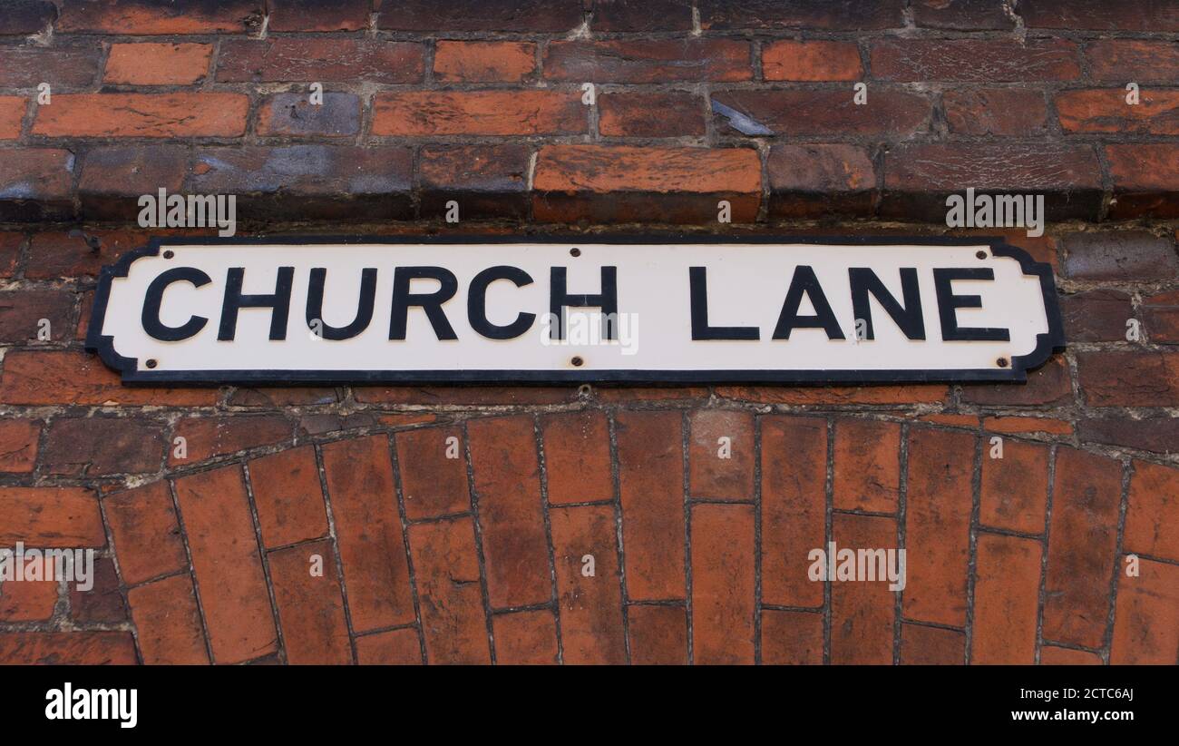 Vecchio cartello inglese che indica Church Lane sulla targa allegata a muratura Foto Stock