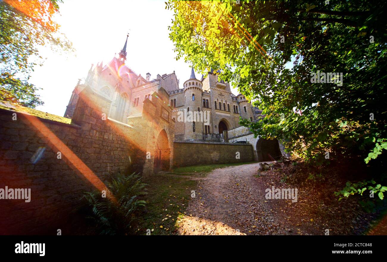 Foto retroilluminata del Castello di Marienburg con il sentiero accanto al muro del castello Foto Stock
