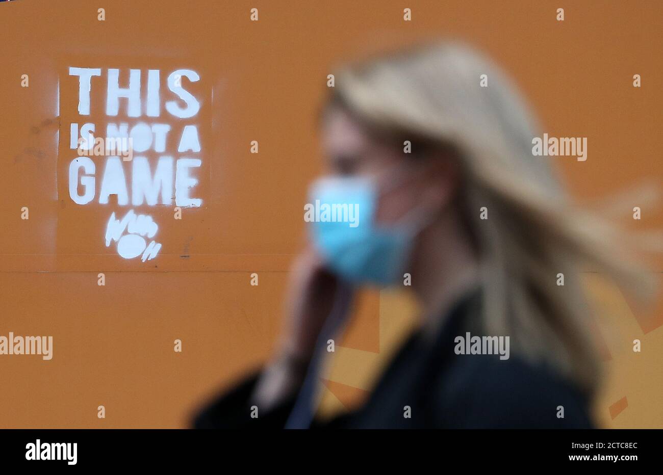 Un membro del pubblico passa davanti a un messaggio su un tabellone a Glasgow, quando il primo ministro Nicola Sturgeon ha annunciato le ultime restrizioni del coronavirus al Parlamento scozzese. Foto Stock