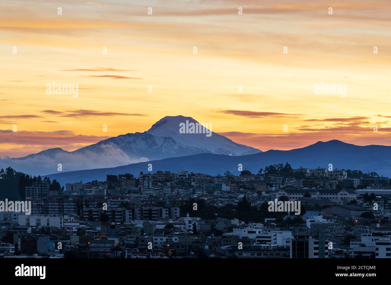 L'alba del vulcano Cayambe e il paesaggio urbano aereo di Quito, Ecuador. Foto Stock