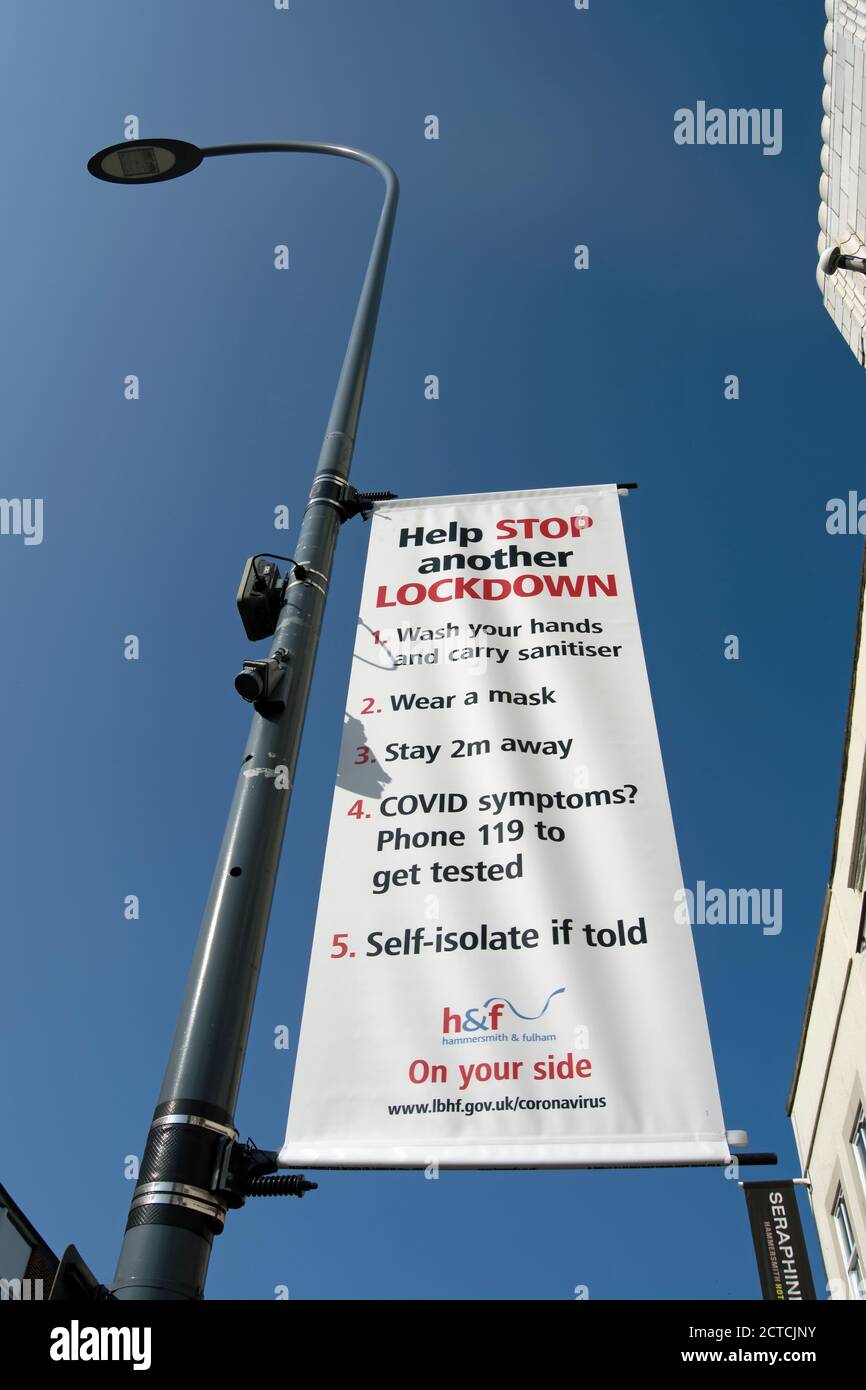 le autorità locali appendono segnali che incoraggiano azioni pubbliche per ridurre la trasmissione del covid 19, a hammersmith, londra, inghilterra Foto Stock