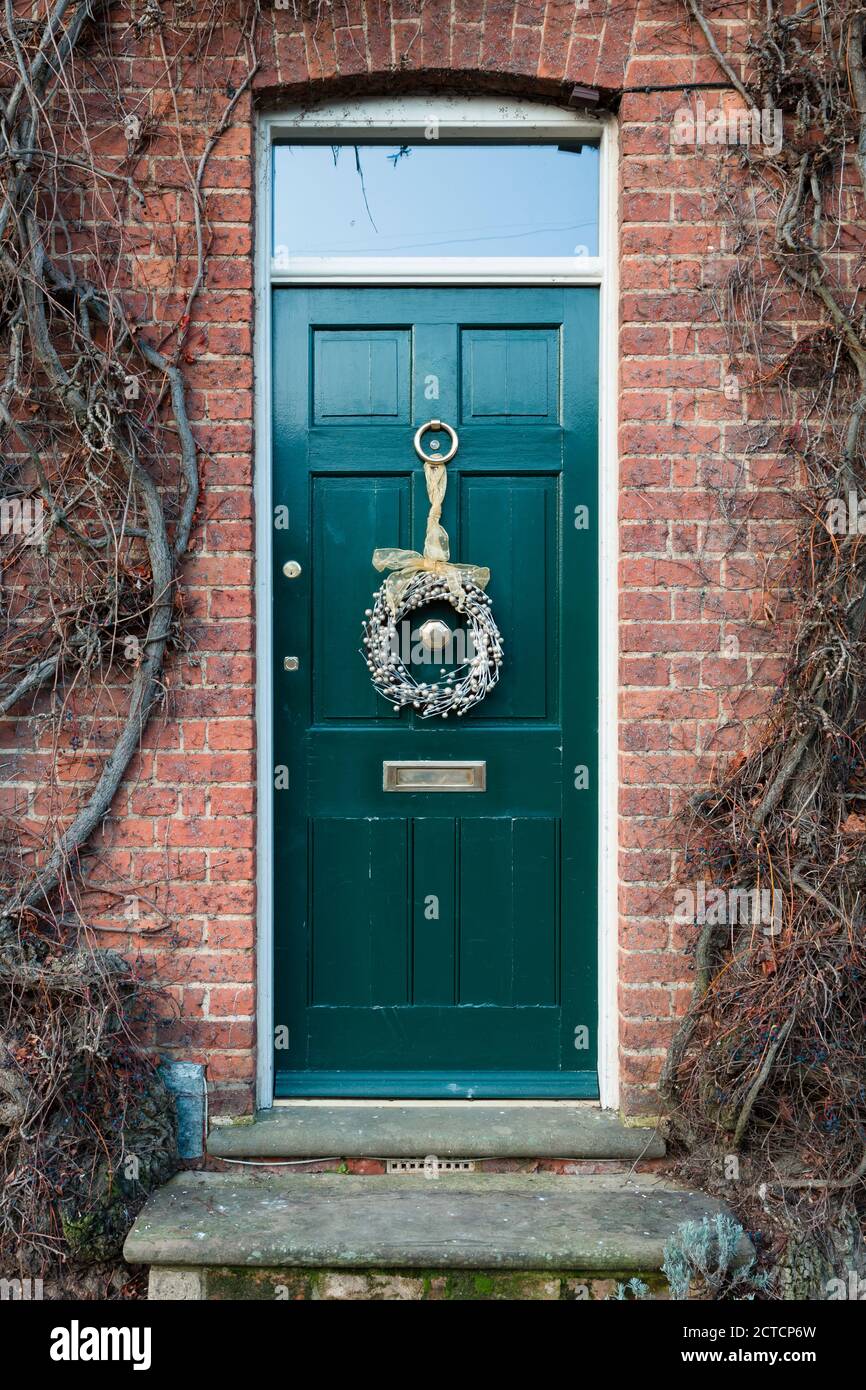 WINSLOW, Regno Unito - 29 dicembre 2019. Porta anteriore fuori di una casa nel Regno Unito al tempo di Natale, porta dipinta di verde, teal, con la corona di Natale Foto Stock