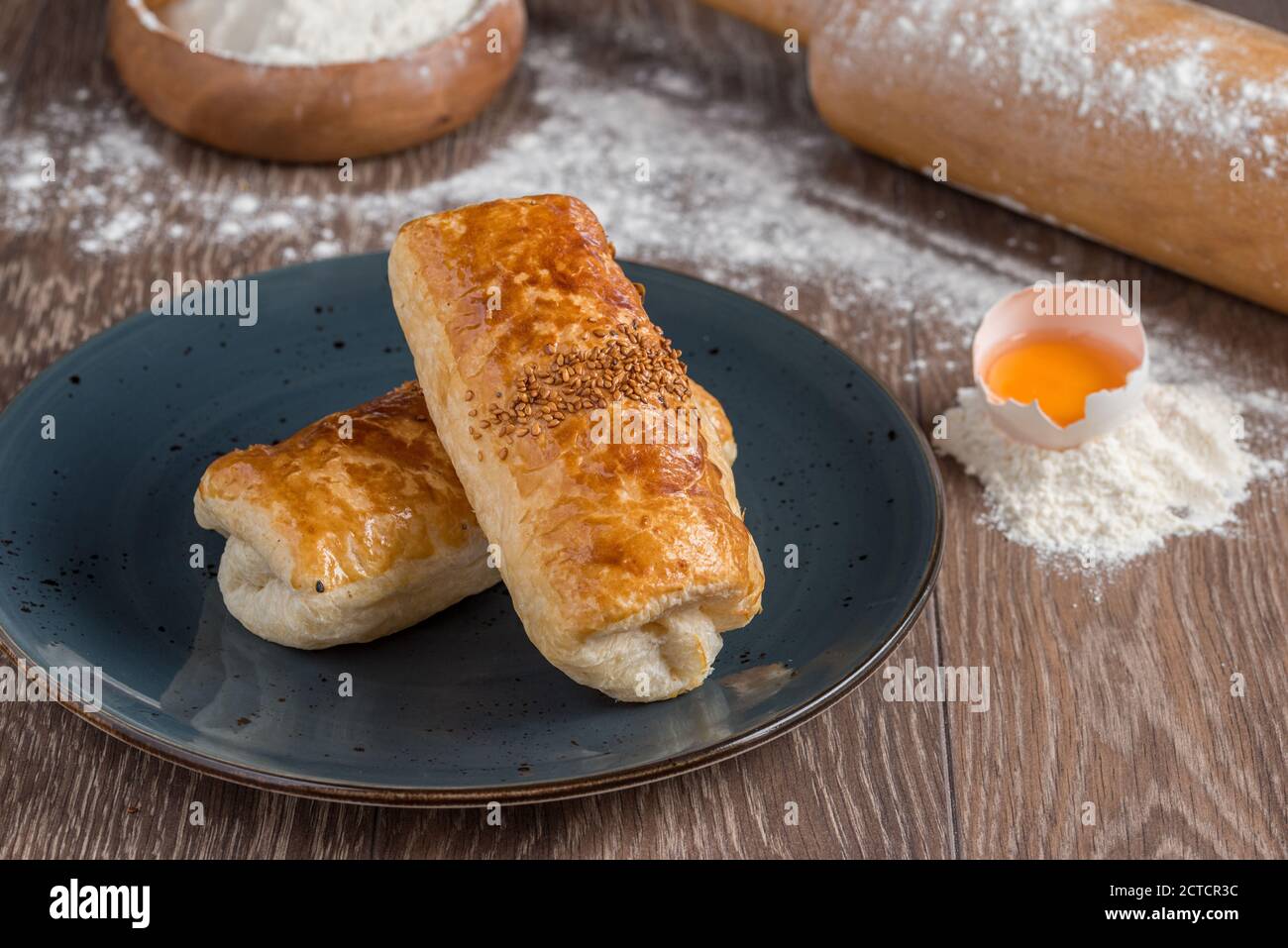 Tradizionale Borek Turco o pasta turca con carne tritata, formaggio e spinaci su sfondo ligneo. Foto Stock