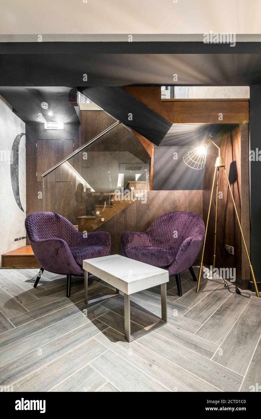 Area di attesa in un lussuoso salone di parrucchiere tra il piano terra e il seminterrato con mobili su misura situato nel cuore di Soho, Londra, Regno Unito. Progetto complet Foto Stock