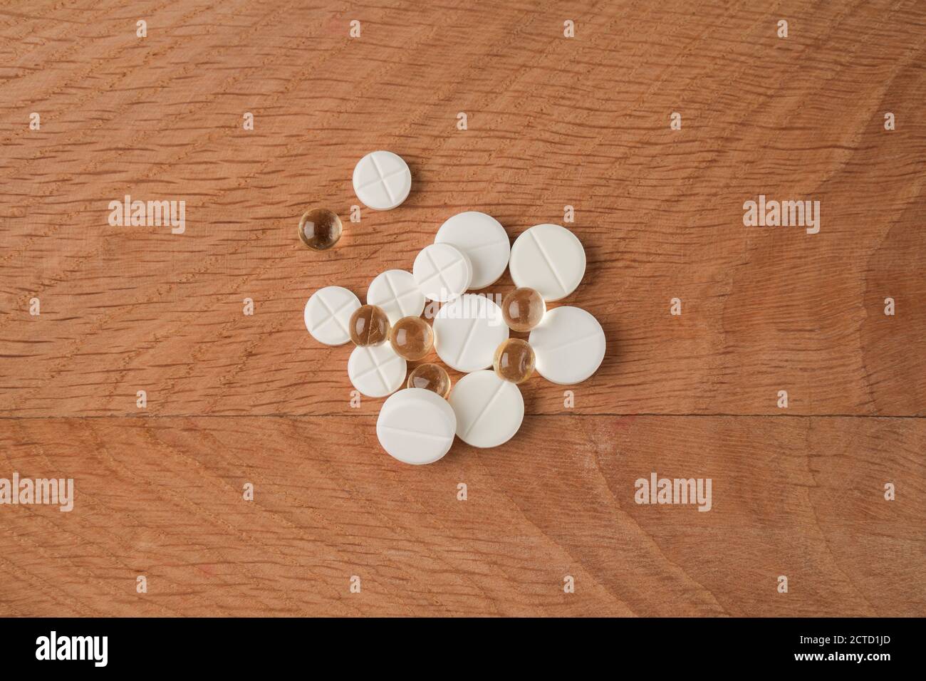 Un mazzo di vari farmaci, pillole che si trovano in giro senza imballaggio, su una tavola di legno Foto Stock