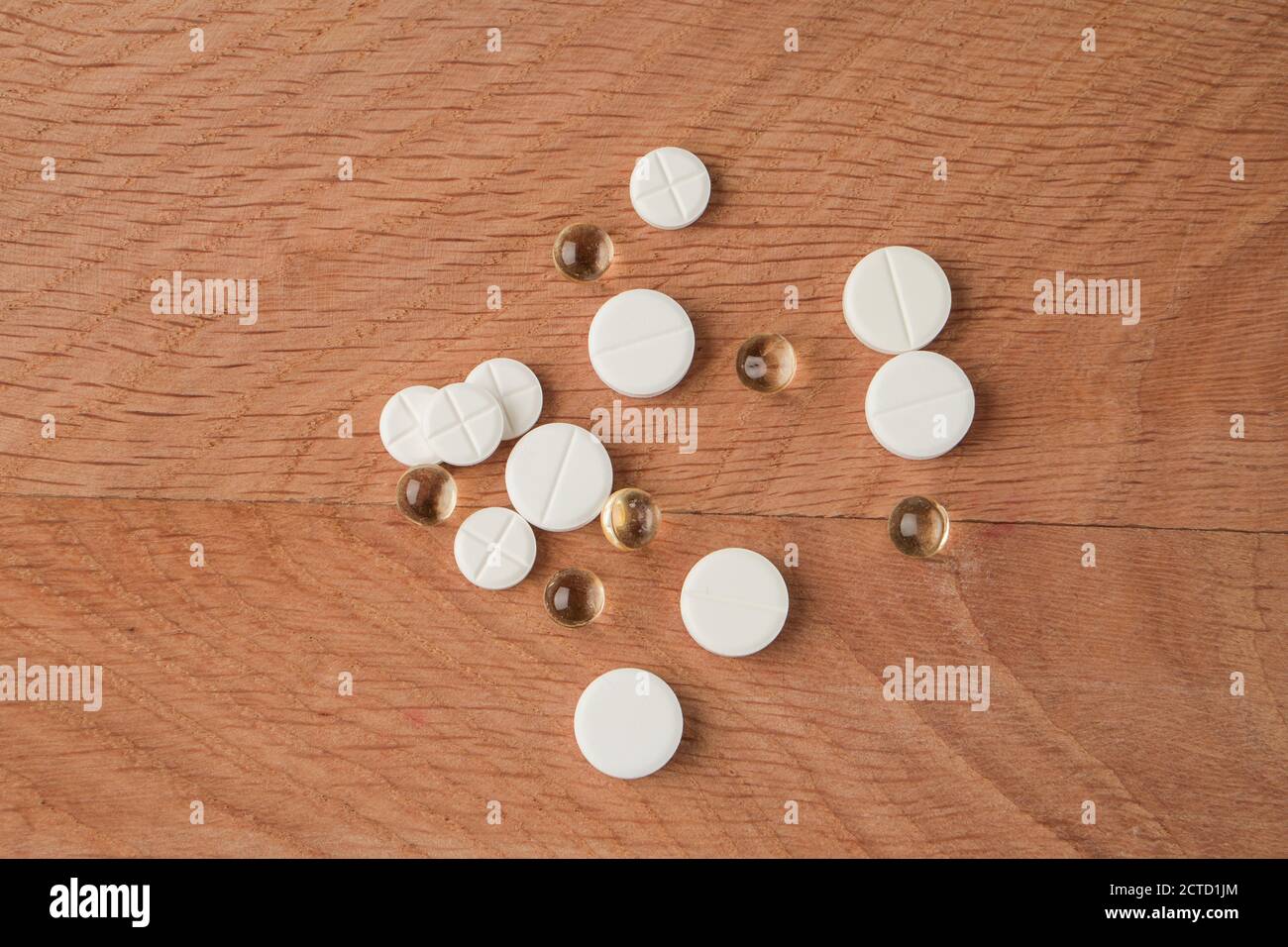 Un mazzo di vari farmaci, pillole che si trovano in giro senza imballaggio, su una tavola di legno Foto Stock