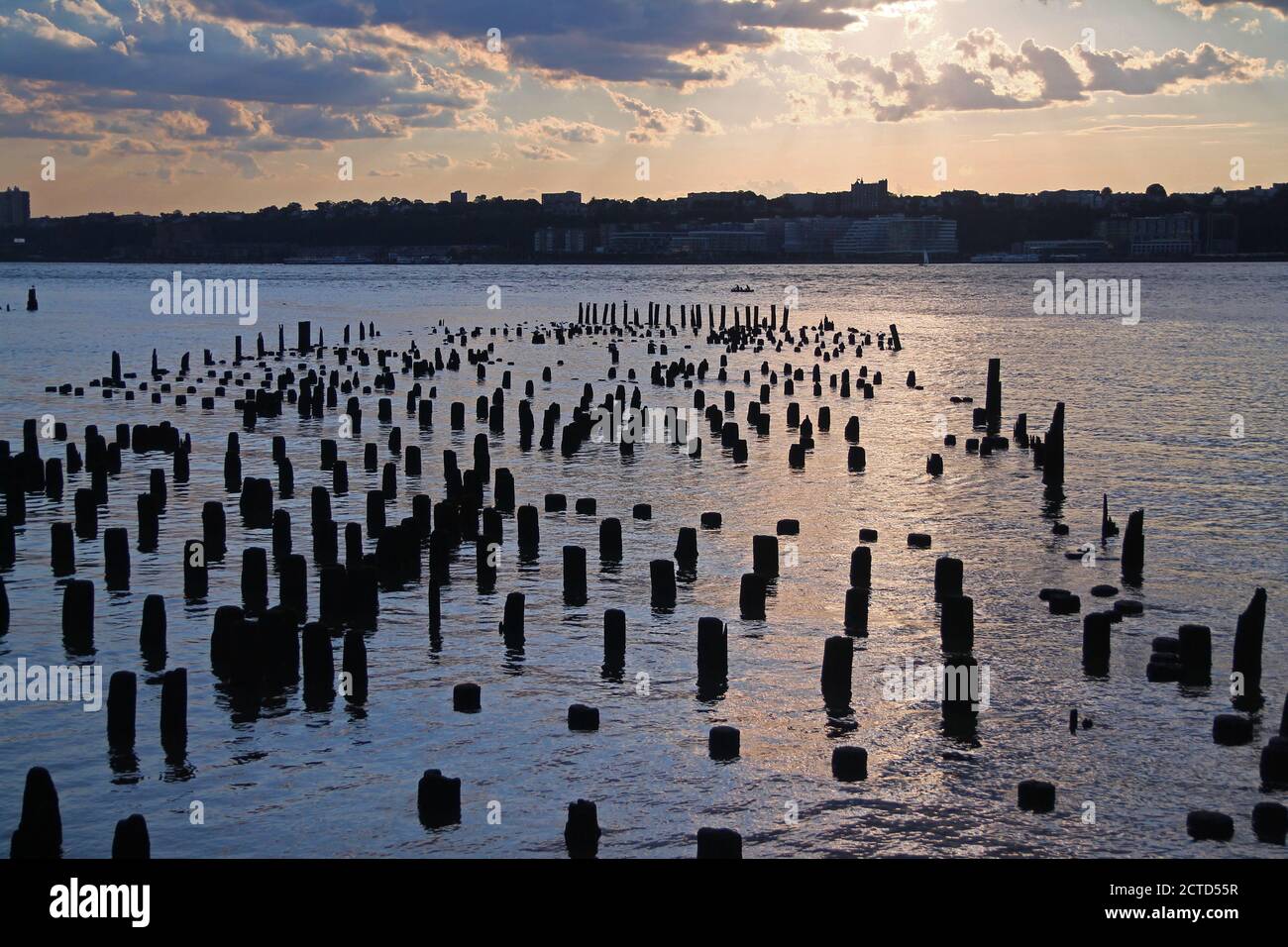 Il tramonto tra i pali del fiume Foto Stock