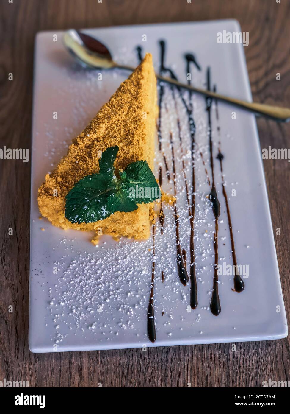 fetta di torta napoleonica su piastra di terracotta bianca con fondo in legno. vista ravvicinata. Foto Stock