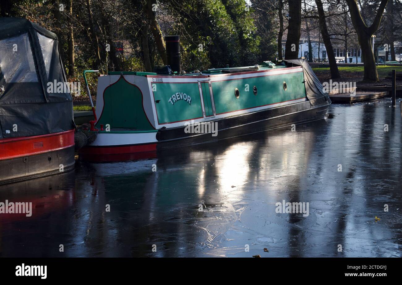 Una barca canale in acqua ghiacciata lungo la bella Basingstoke Canale in Surrey Foto Stock