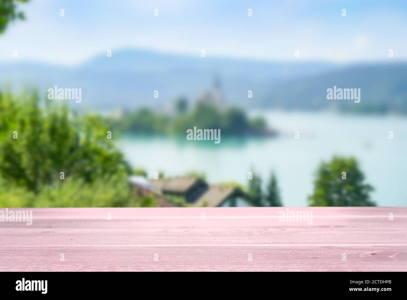 un tavolo di legno bianco con vista su un alpino lago sullo sfondo Foto Stock