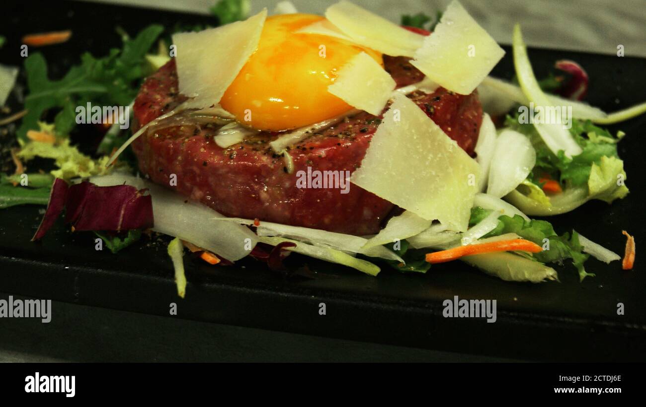 Tartare di bovino, piatto velluto gourmet. Grandi cuochi italiani preparano quetto piano, composto in carne di bovino battuto a coltello e condito. Foto Stock