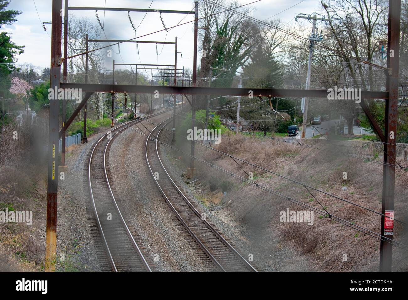 Guardando attraverso una fence di metallo ad una ferrovia in Suburban Pennsylvania Foto Stock