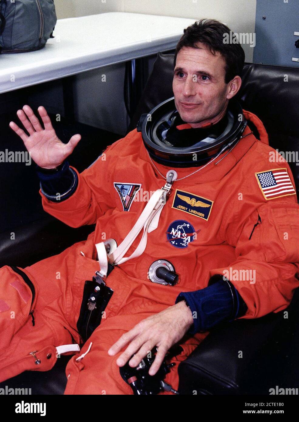 STS-81 Lo specialista di missione Jerry Linenger onde per la telecamera nel suo lancio/entry tuta e casco in camera suitup delle operazioni e checkout (O&C) edificio. Foto Stock
