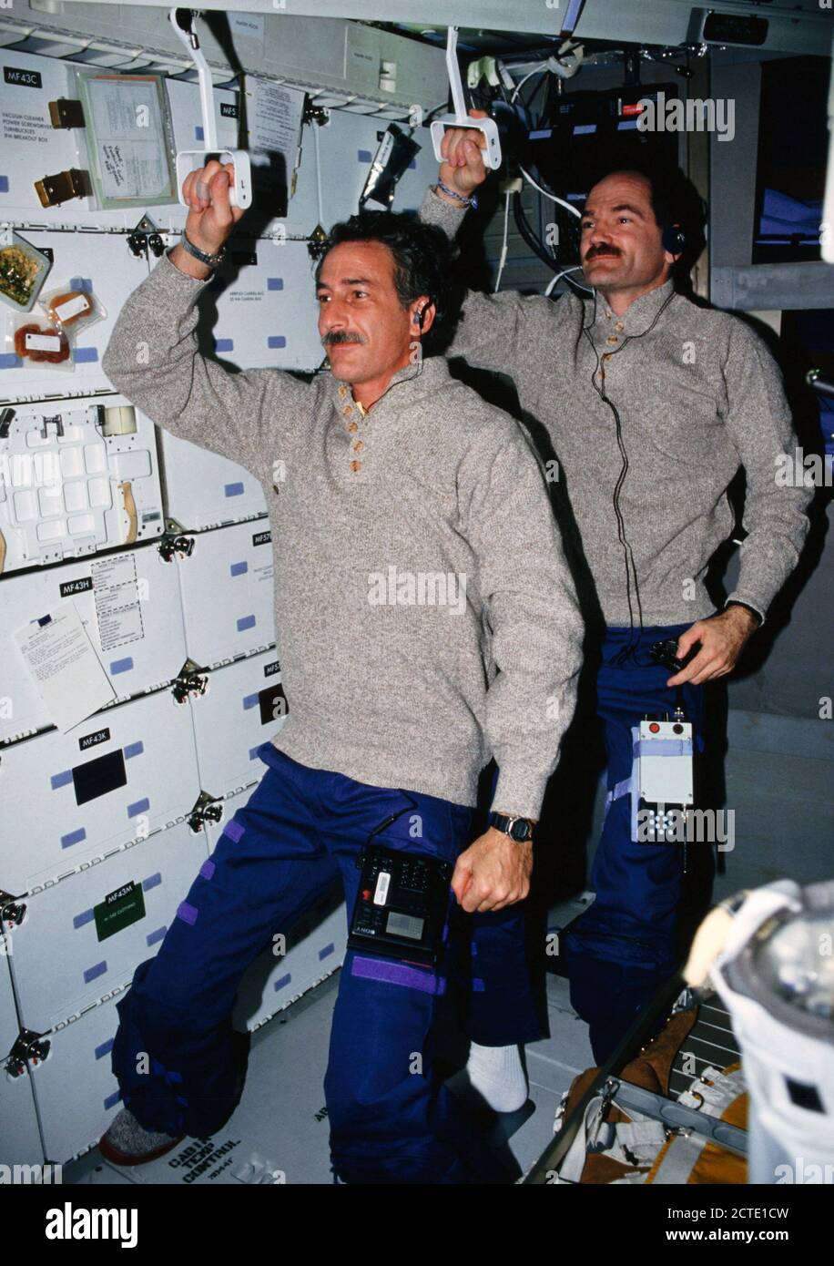 STS-35 Lo specialista di missione (MS) Jeffrey A. Hoffman (anteriore) e pilota Guy S. Gardner, azienda di sviluppo obiettivo di prova (DTO) 634 compattatore di rifiuti di maniglie per il soffitto, 'commutare' per lavorare sul middeck della Columbia, Orbiter veicolo (OV) 102. Foto Stock