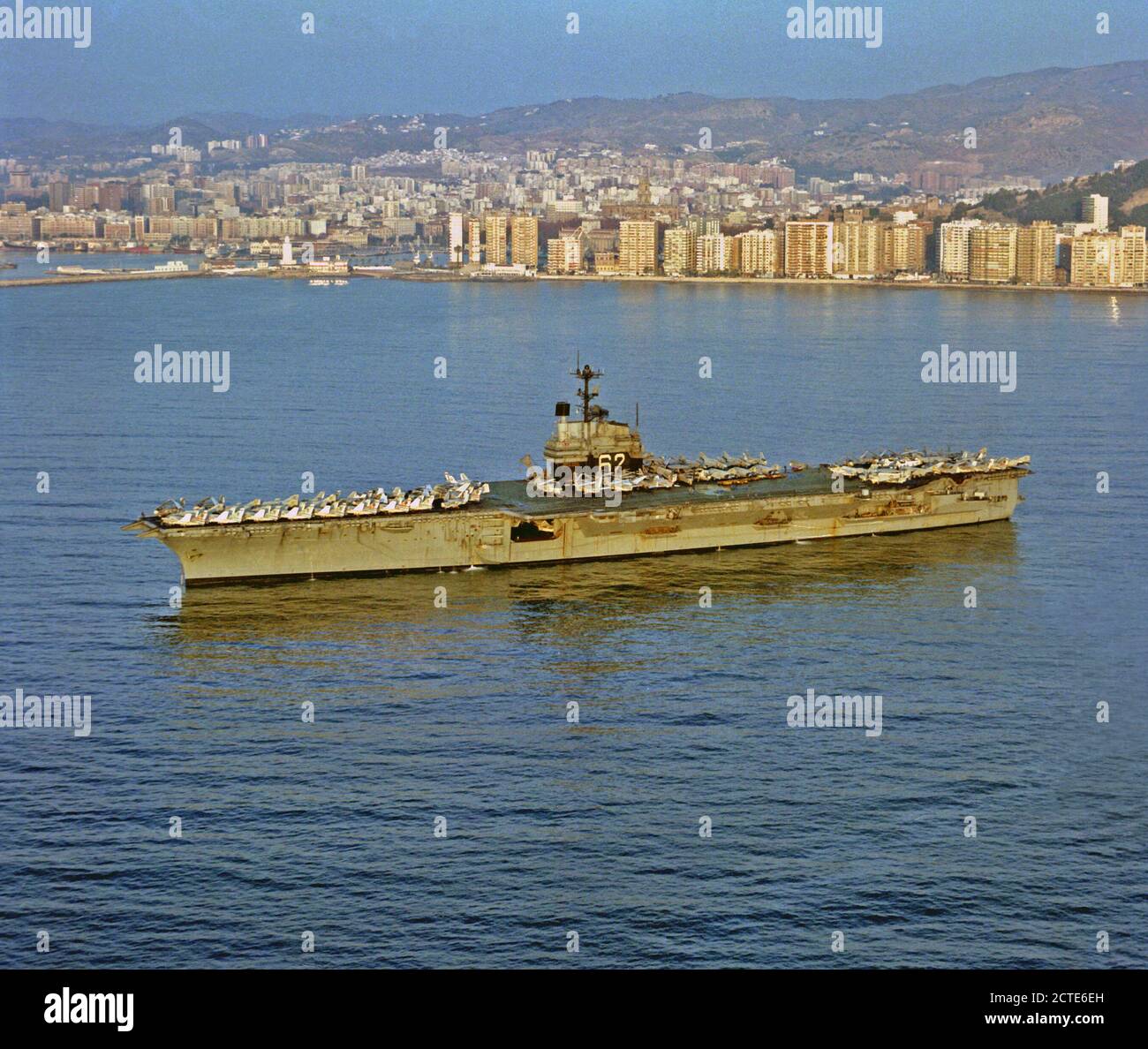 1979 - Una porta vista di prua della portaerei USS INDIPENDENZA (CV-62) ancorati nel porto. Foto Stock