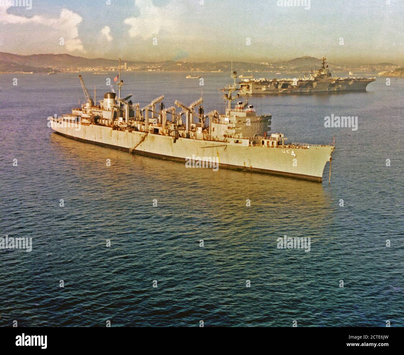 1979 - una prua dritta vista del rapido supporto di combattimento nave USS DETROIT (AOE-4) e dritta vista laterale della portaerei USS INDIPENDENZA (CV-62), mentre le due navi sono ancorati nel porto. Foto Stock