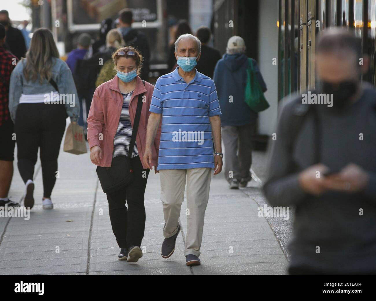 Vancouver, Canada. 22 settembre 2020. Le persone che indossano maschere facciali camminano su una strada nel centro di Vancouver, British Columbia, Canada, il 22 settembre 2020. Mentre la pandemia di COVID-19 sta accelerando nel paese, l'Agenzia di Sanità pubblica del Canada (PHAC) il martedì ha avvertito che se i canadesi non intensiscono le misure preventive, il coronavirus potrebbe spargersi fuori di controllo e innescare un'ondata di infezioni più grande di quella prima. Credit: Liang Sen/Xinhua/Alamy Live News Foto Stock