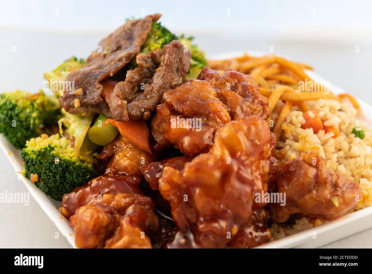 Ordinare cibo da ristorante per qualche piatto misto con manzo mongolo, riso, broccoli e pollo all'arancia. Foto Stock