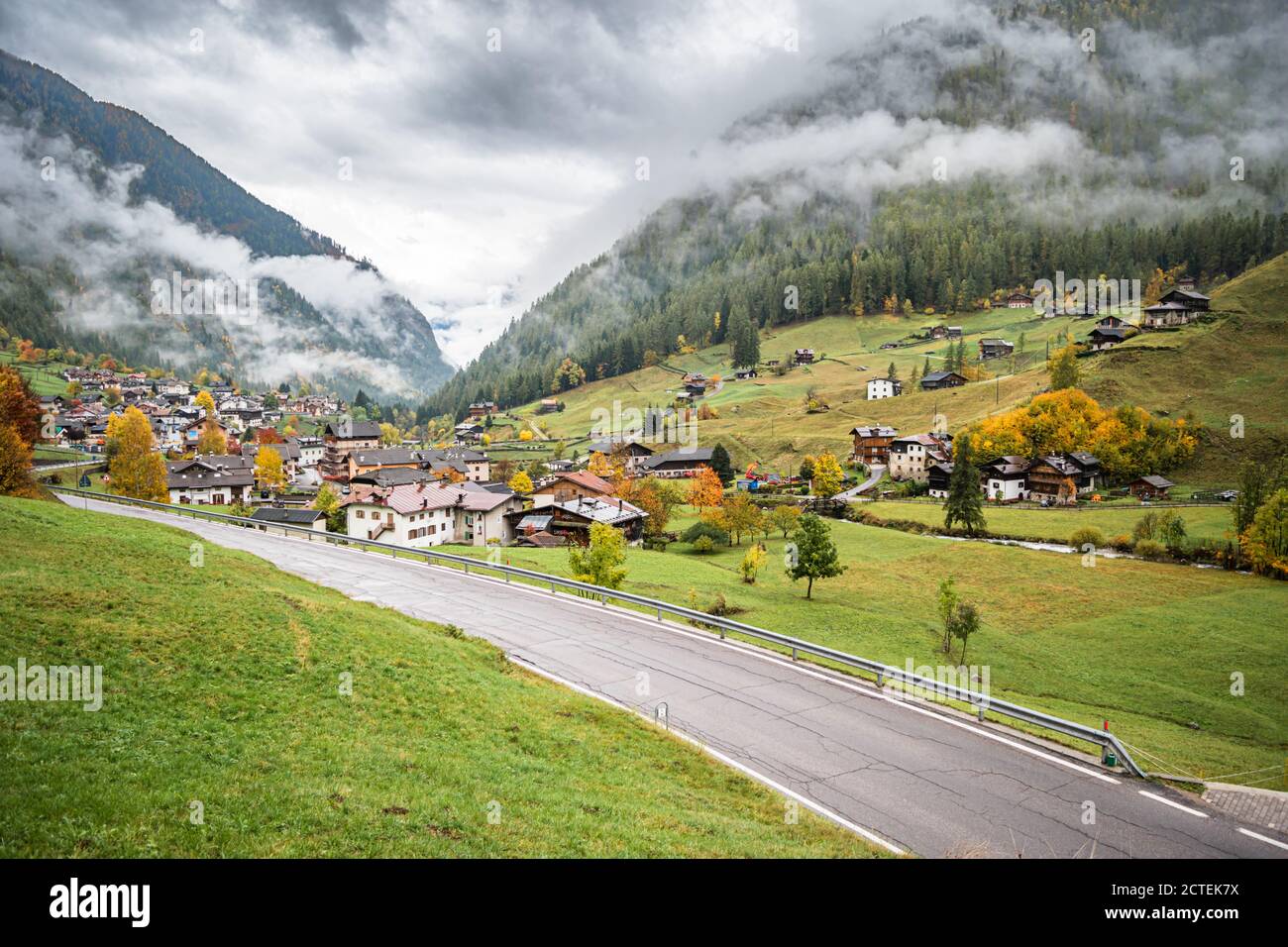 Paesaggio di strada lungo alcuni piccoli borghi del nord Italia sulle pendici delle Dolomiti all'inizio dell'autunno. Foto Stock