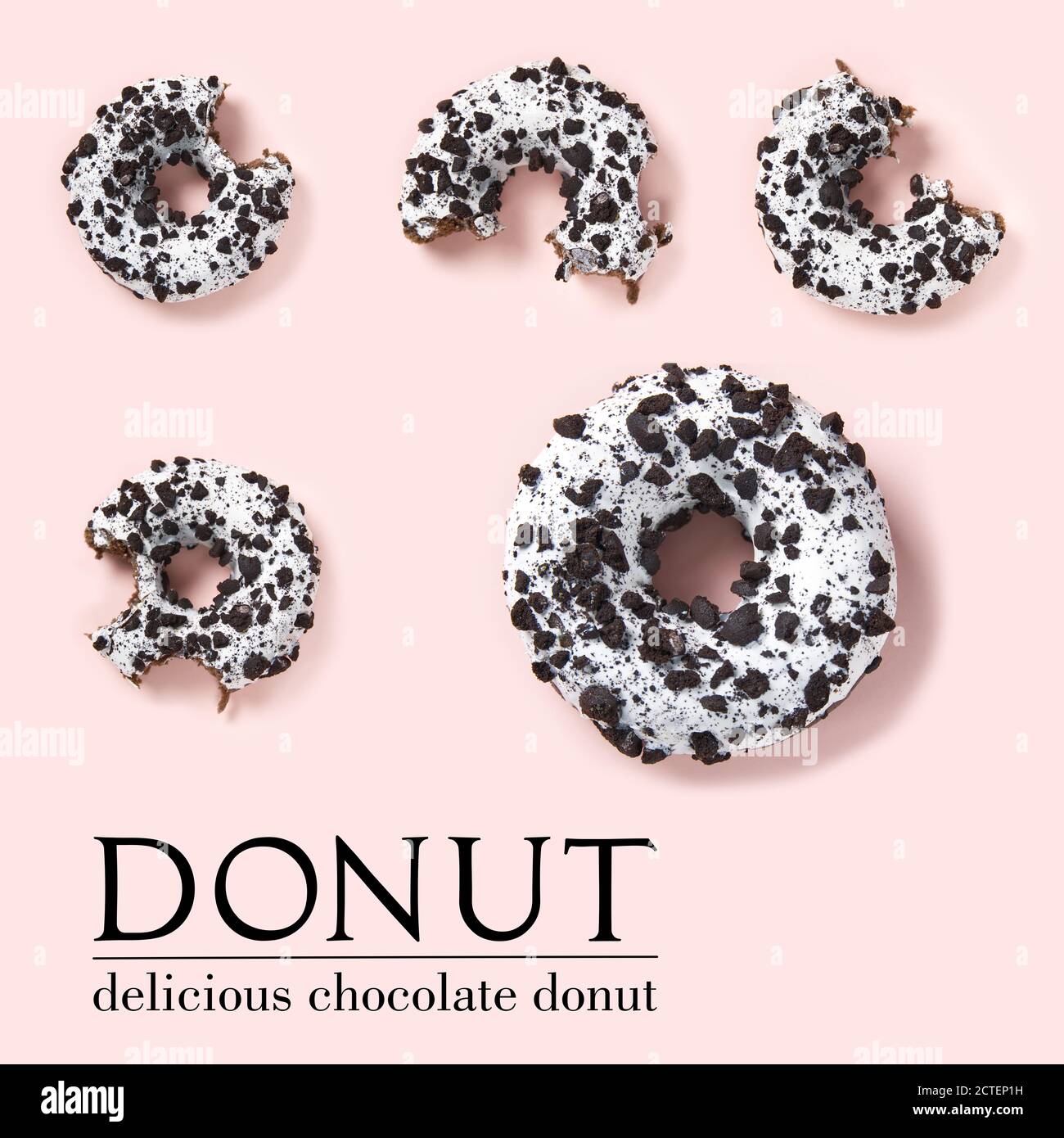 composizione creativa di ciambelle su sfondo rosa. Piatto posare deliziose ciambelle di cioccolato con stuzzicini e testo semplice. Foto Stock