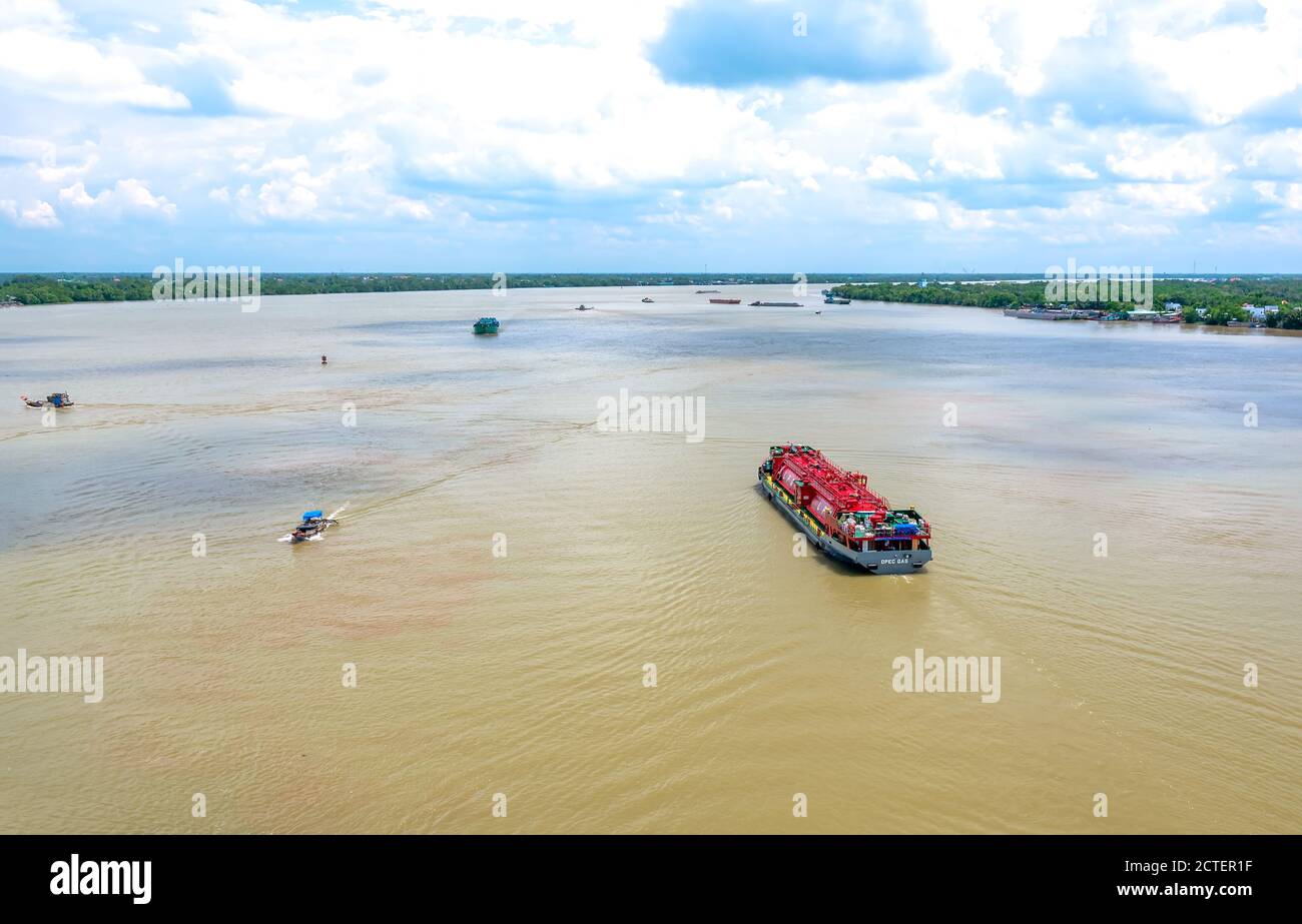 Le navi che trasportano gas sul fiume Mekong inferiore sono ricche di alluvione nelle mattine d'estate, aiutando lo sviluppo economico a Tien Giang, in Vietnam Foto Stock