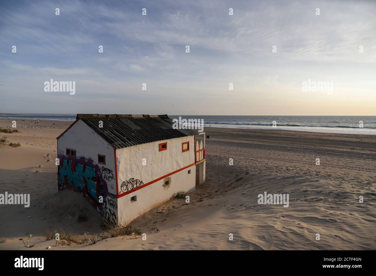 Bella caratteristica casa in legno lungo la spiaggia a Costa da Caparica a Lisbona, Portogallo. Piccolo villaggio sulla spiaggia al tramonto di fronte ALLA A Foto Stock