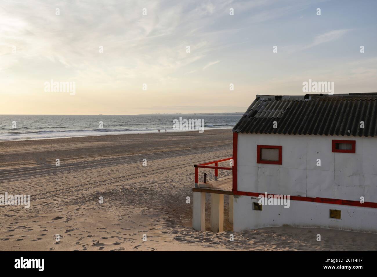 Bella caratteristica casa in legno lungo la spiaggia a Costa da Caparica a Lisbona, Portogallo. Piccolo villaggio sulla spiaggia al tramonto di fronte ALLA A Foto Stock