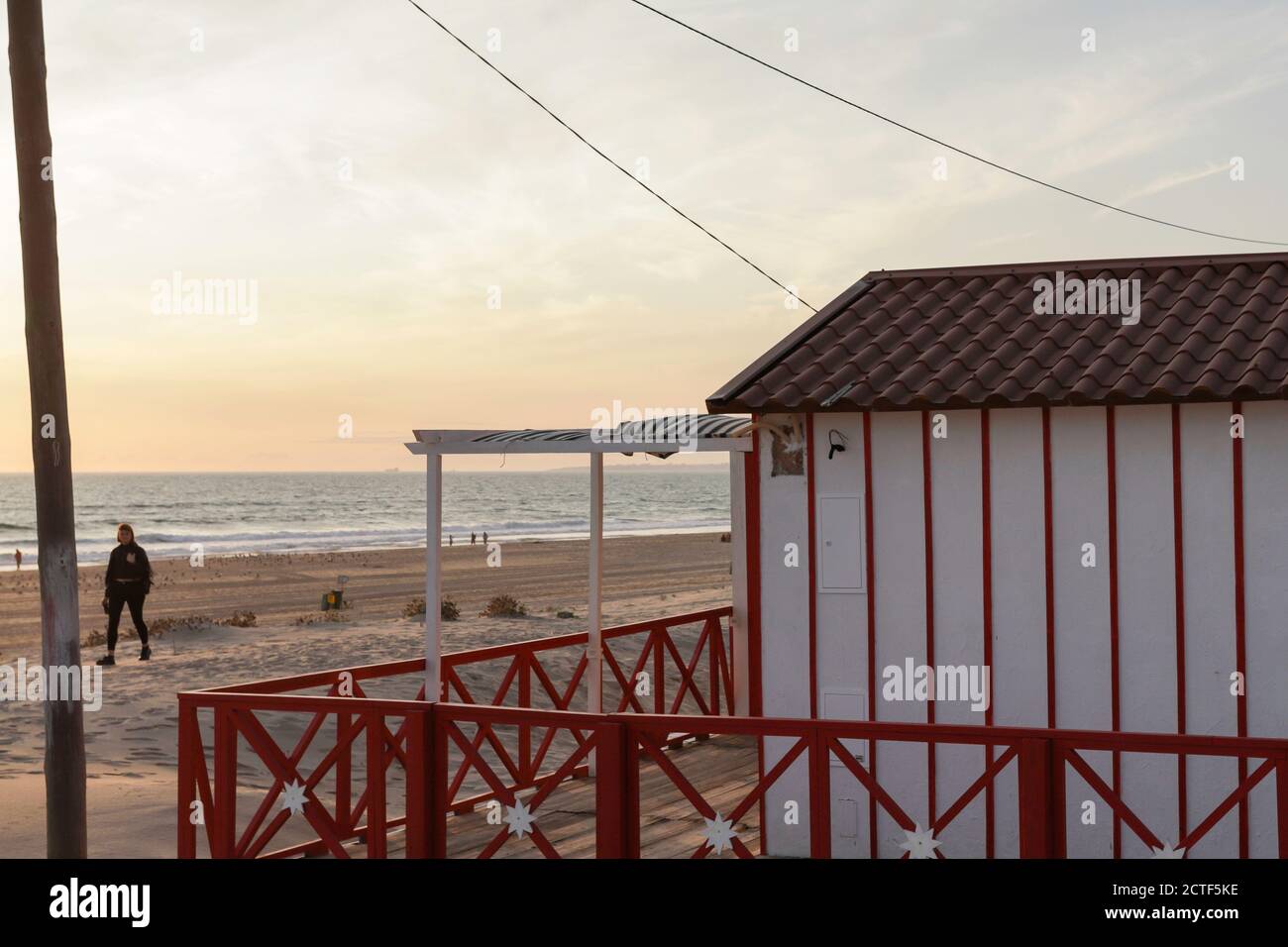 Bella caratteristica casa in legno lungo la spiaggia a Costa da Caparica a Lisbona, Portogallo. Piccolo villaggio sulla spiaggia al tramonto di fronte ALLA A Foto Stock