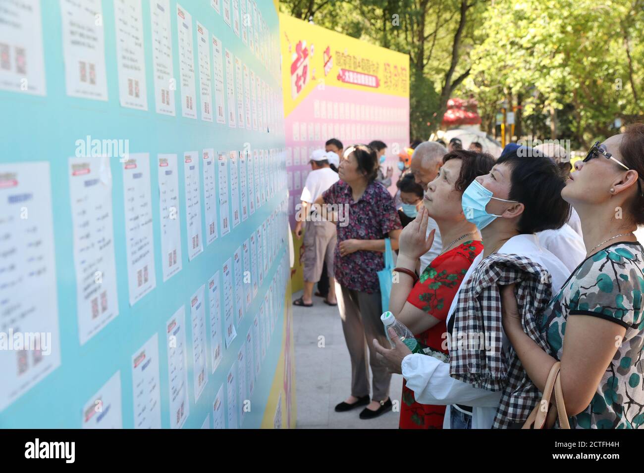 I genitori esaminano un consiglio con informazioni personali per trovare le date per i loro bambini all'evento pubblico di preparazione delle partite che si tiene al Dinghai Park nella città di Zhoushan, Foto Stock